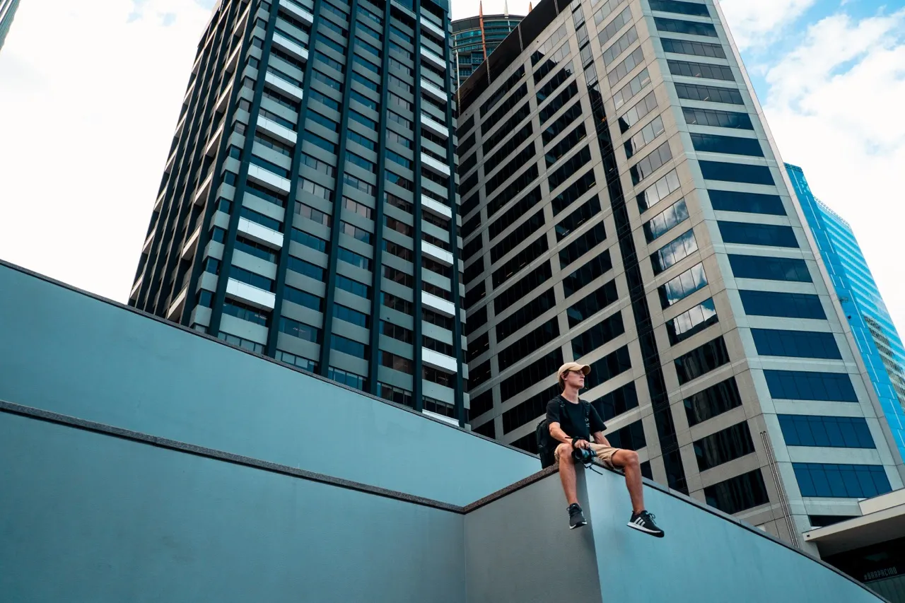 Person sitting beside building